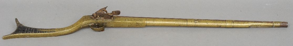 An 18th/19th century Albanian brass mounted gun
With chip carved stock and engraved decoration.  110