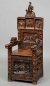 A 19th century carved oak open armchair 
Profusely carved with panels of various figures, the seat