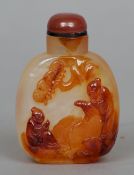 A Chinese carved agate snuff bottle
Worked with a pair of figures in a landscape.  7.5 cms high.