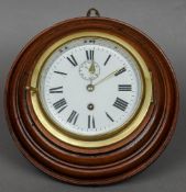 A late 19th/early 20th century mahogany cased wall clock
The deep brass bezel enclosing the white