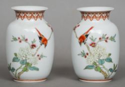 A pair of small Chinese porcelain vases
Each decorated with a bird on a blossoming branch, the