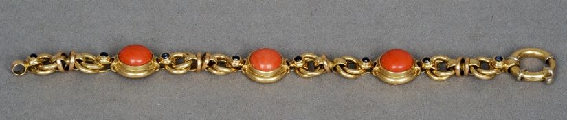 An 18 ct gold bracelet
The circular links set with cabochon, coral and sapphires.  19 cms long.