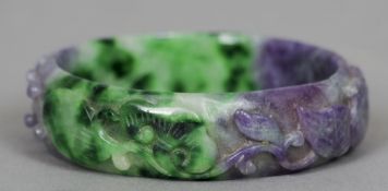 A lilac and green jade bangle
With carved floral decoration.  7.25 cms diameter.   CONDITION