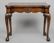 An early 20th century Georgian style walnut card table
The hinged shaped top enclosing the