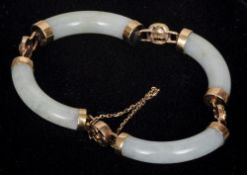 A Chinese unmarked gold and jade set bracelet
Of reticulated bangle form.  6.5 cms wide.   CONDITION