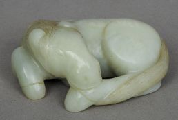 A Chinese carved green and russet jade pebble
Worked as a recumbent horse.  Approximately 7 cms