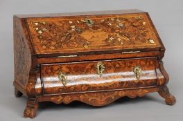 A 19th century Dutch marquetry inlaid miniature bureau
Of bombe form, the profusely inlaid fall