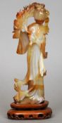 A Chinese banded agate figural carving
Formed as a lady holding a flowering branch, mounted on a