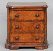 A Victorian miniature burr walnut chest of drawers
The moulded shaped top above three drawers,