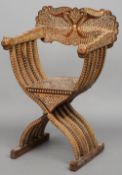 A 19th century Indian bone and ebony inlaid X-frame armchair
The peacock inlaid back above the