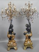 A pair of Venetian blackamoor form candelabra
Each with scrolling floral branches issuing facet