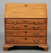 An 18th century yewwood bureau
The hinged fall enclosing an arrangement of drawers and pigeon holes,