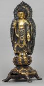 A Chinese gilt bronze figure of Buddha
Modelled standing on a lotus cast plinth, supported by the