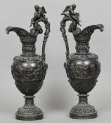 A pair of 19th century patinated bronze ewers
Each ornately cast with a cherub mounted handle, the
