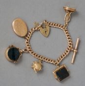 A 9 ct gold watch chain
Set with various fobs, charms, etc.  approximately 18 cms long.