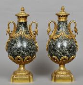 A pair of gilt metal mounted marble baluster urns
Each with pineapple finial above swan neck handles