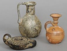 A Roman glass jug, circa 2nd/3rd century AD, a pottery oil lamp and a small Cypro-Archaic gourd