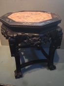 A pair of Chinese marble inset hardwood urn stands
The octagonal tops above a carved frieze, beast