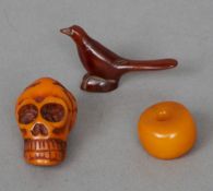 A 16th century amber rosary 
Carved as skull; together with a plain bead; and a stylised bird