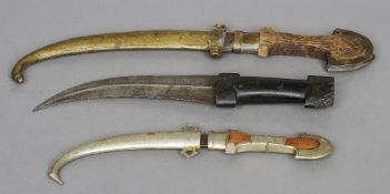 Three jambiya
One with an engraved brass scabbard.  The largest 39 cms long.  (3)   CONDITION