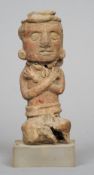 A Pre-Columbian pottery figure
Formed seated with arms crossed, mounted on a later plinth base.