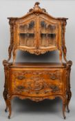 A 19th century Italian carved walnut glazed cabinet
The scroll carved serpentine pediment