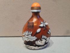 A Chinese overlaid glass carved snuff bottle
Worked with fish, ducks and insects with four character