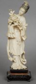 A 19th century Chinese carved ivory group modelled as Guanyin
Holding a floral spray, standing on