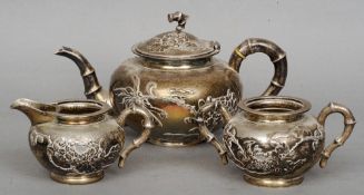 A Chinese silver three piece tea set, maker's mark of Luen Wo
Each piece with embossed floral