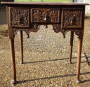 A Georgian carved oak lowboy
With three frieze drawers, standing on tapering legs with pad feet.  69