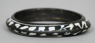 An early Roman glass bangle
The black ground with bands of white decoration.  9.5 cms diameter.