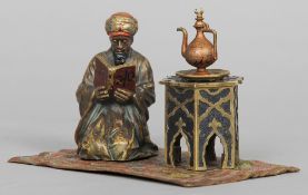 An Austrian cold painted bronze figural inkwell
Formed as an Arab man kneeling on a carpet and