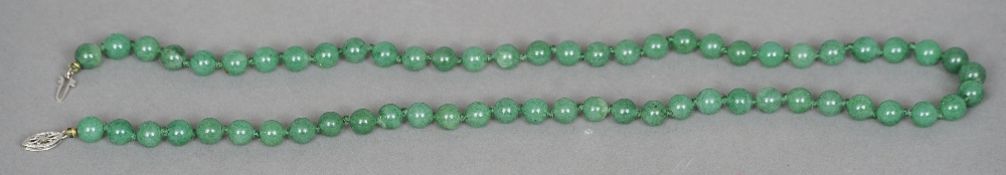 A string of jade beads
Set with a pierced clasp.  50 cms long.   CONDITION REPORTS:  Overall good,