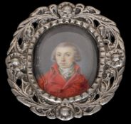 A 19th century miniature on ivory depicting a gentleman
Wearing a red coat, housed in a pierced oval