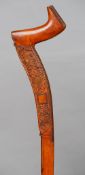 A 19th century Irish carved wooden walking stick
Of unusual flattened form, decorated with foliage