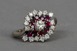 An unmarked white gold, diamond and ruby ring
Of swirling target form.  2 cms wide.   CONDITION