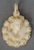 A 19th century ivory  pendant
Centrally carved with a female bust bordered by roses.  5.5 cms high.