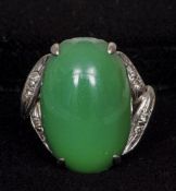 A 14 ct white gold diamond and jade set ring
The central cabochon jade stone above the pierced