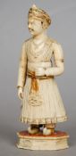An 18th century Indian carved ivory figure formed as a dignitary in regal attire
With traces of