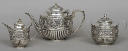 An Indian white metal three piece tea setStop gadrooned and decorated with Eastern figures.  The