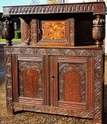 A 17th century oak court cupboard
Of small proportions, with carved and inlaid details.  114.5 cms