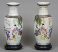 A pair of Chinese porcelain vases
Each decorated with a female figure and children in a garden,