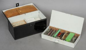 A compartmentalized black japanned tackle box
Containing accessories, flies, lures, swivels and