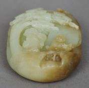 A Chinese carved green and russet nephrite jade group
Worked as two figures beneath a tree