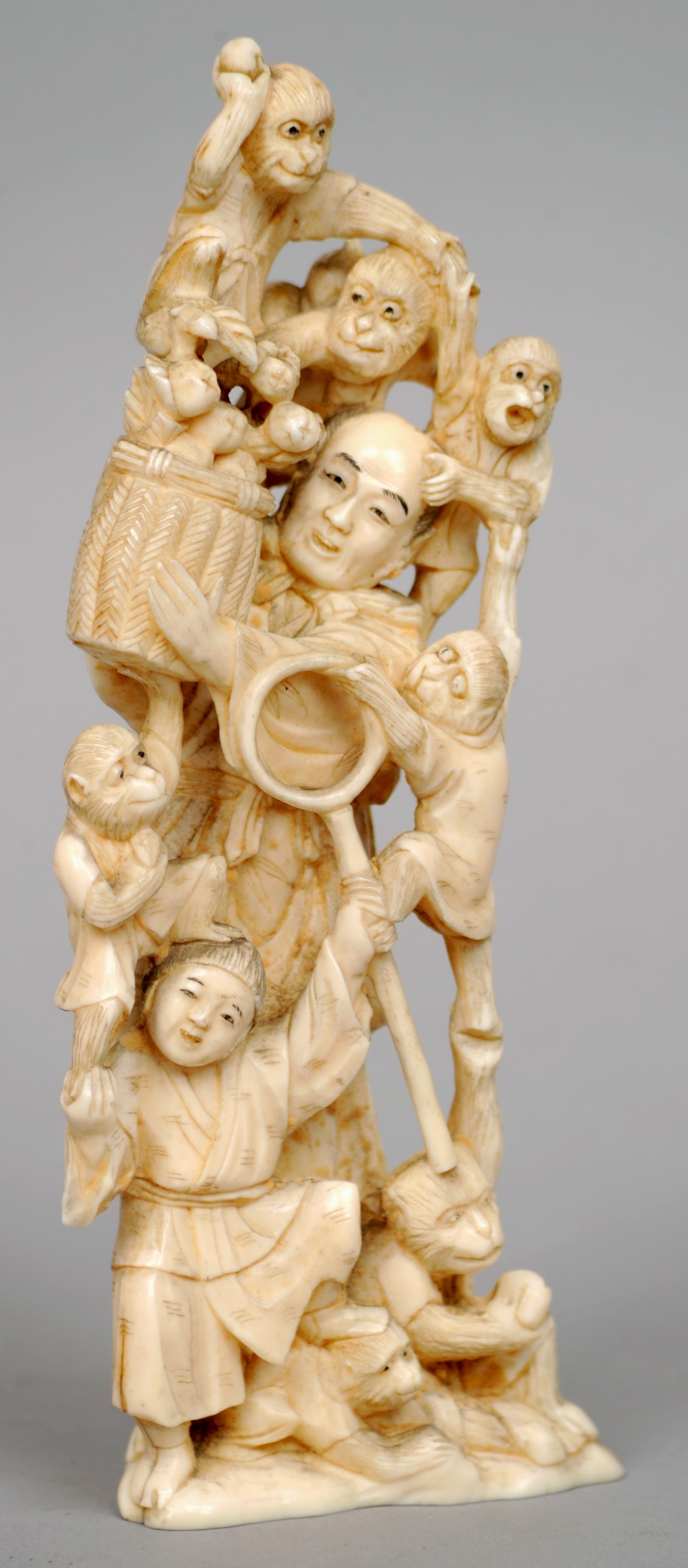 A 19th century Japanese carved ivory okimono
Formed as a fruit farmer and his son amongst playful