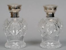 A pair of George V silver topped cut glass scent bottles, one hallmarked Birmingham 1926, the