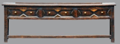 An 18th century and later oak dresser base
The moulded rectangular top above two geometrically