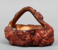 An Eastern carved gnarled root wood basket
The interior lacquered.  19 cms wide.    CONDITION