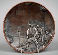 A late 19th century Japanese patinated bronze plate
Decorated in relief with samurai warriors in a