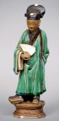 A 19th century Chinese pottery figure
Formed as a gentleman wearing a green glazed robe and